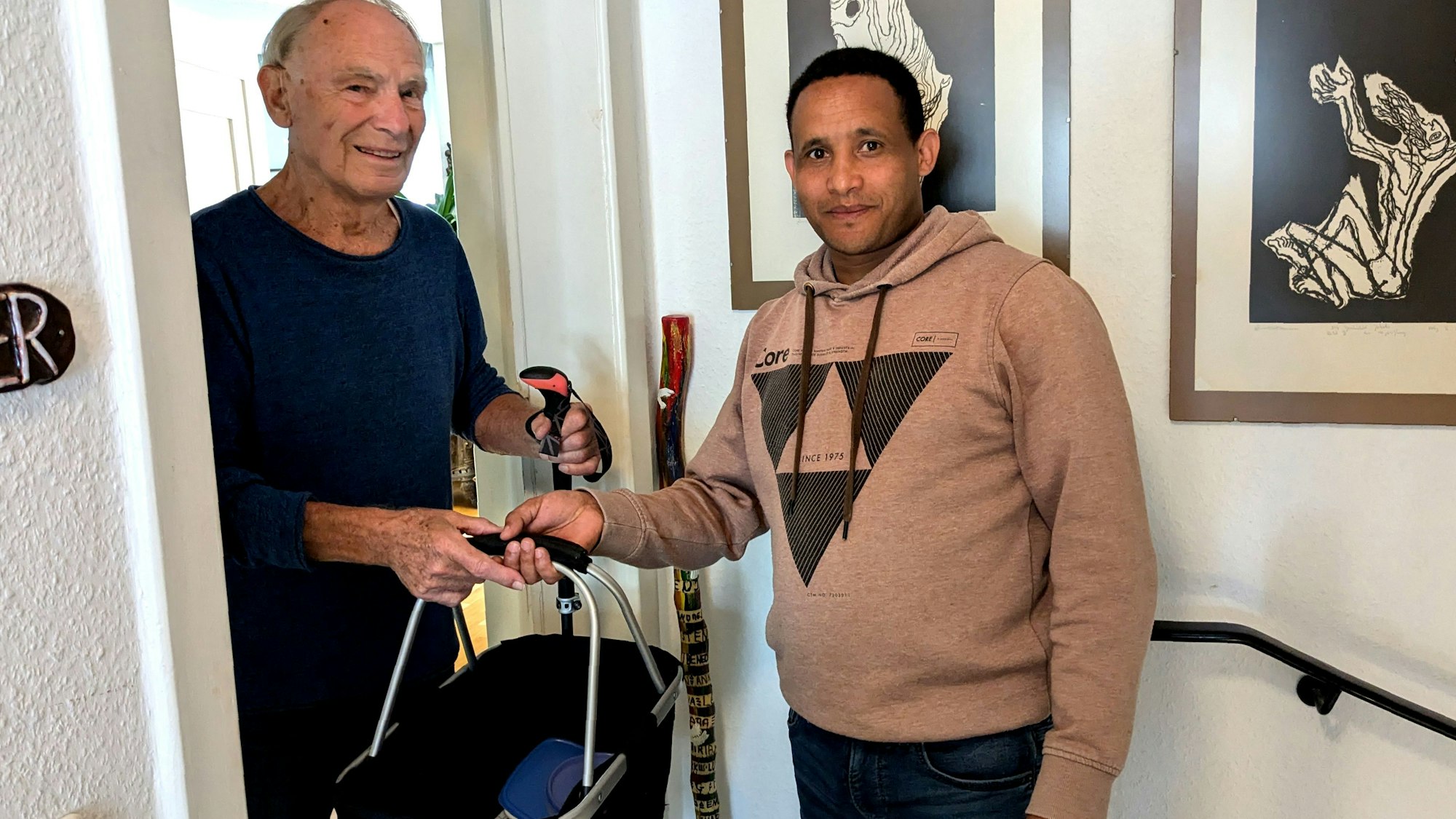 Tesfay überreicht seinem Adoptivvater Dr. Herbert Kaefer einen Einkaufskorb.