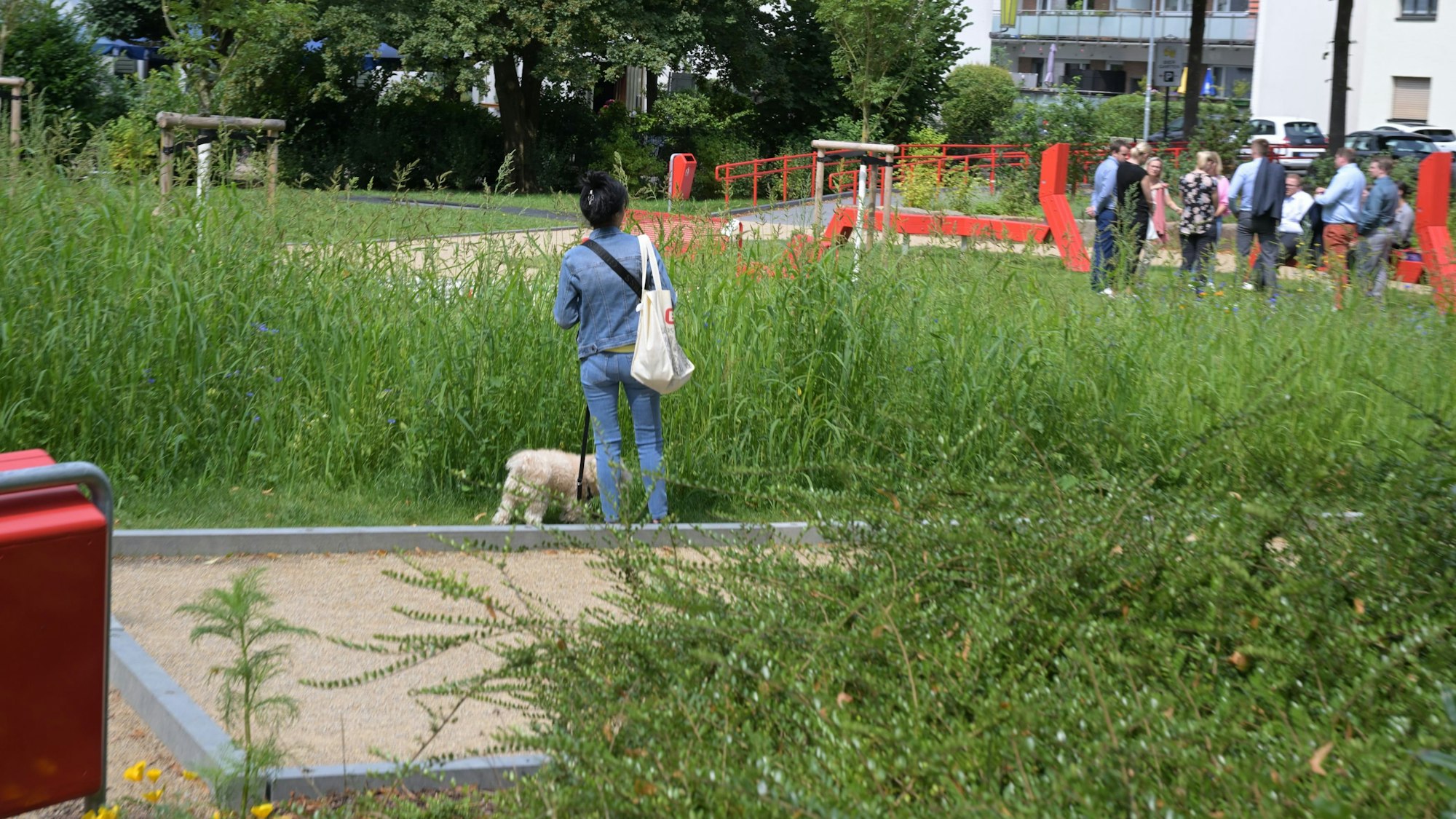 Eine Frau seht mit ihrem Hund im Mehrgenerationenpark.