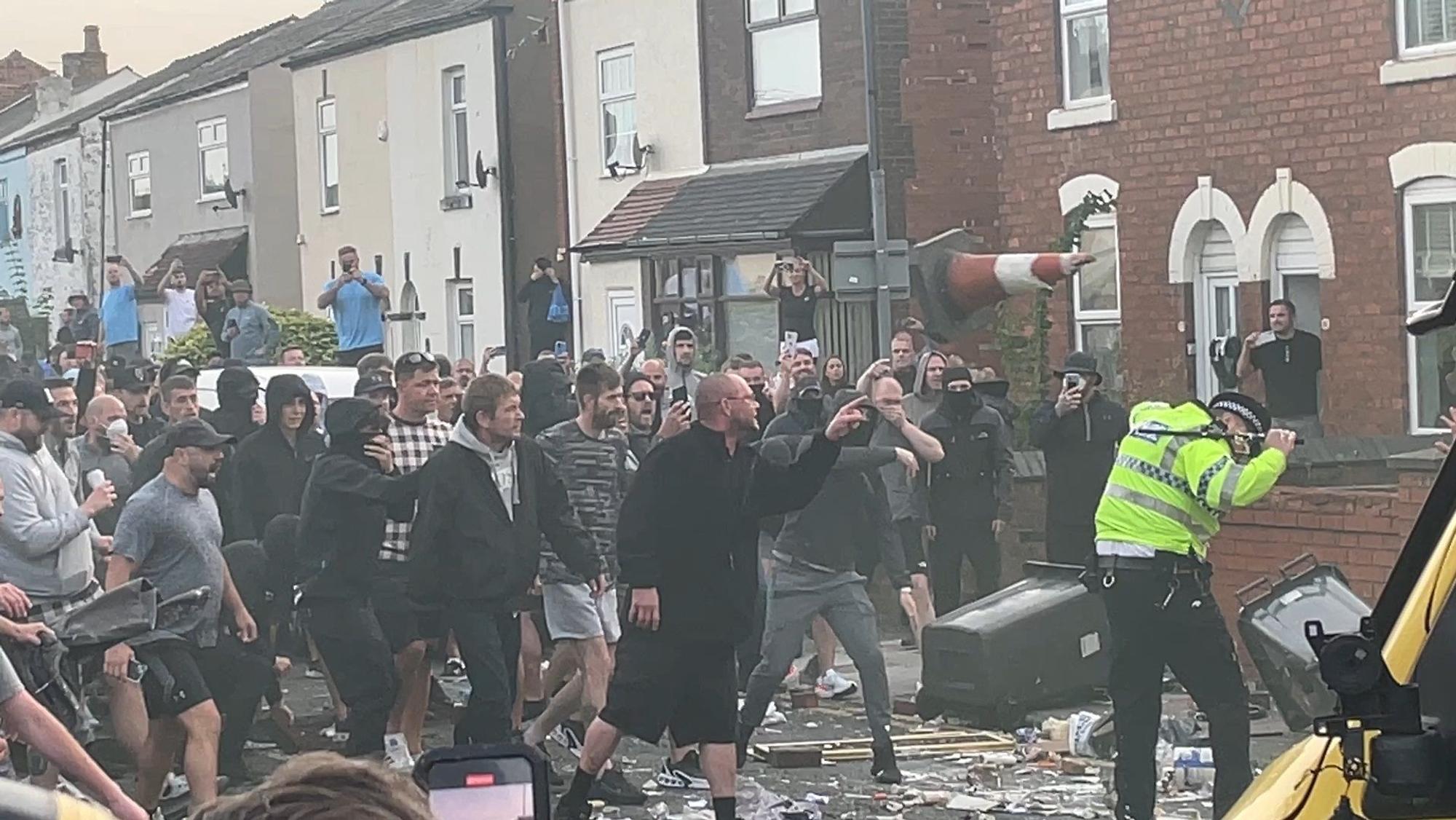 30.07.2024, Großbritannien, Southport: Menschen stoßen während Unruhen mit der Polizei zusammen, in der Nähe des Ortes, an dem am Vortag drei Mädchen bei einem Messerangriff getötet wurden.