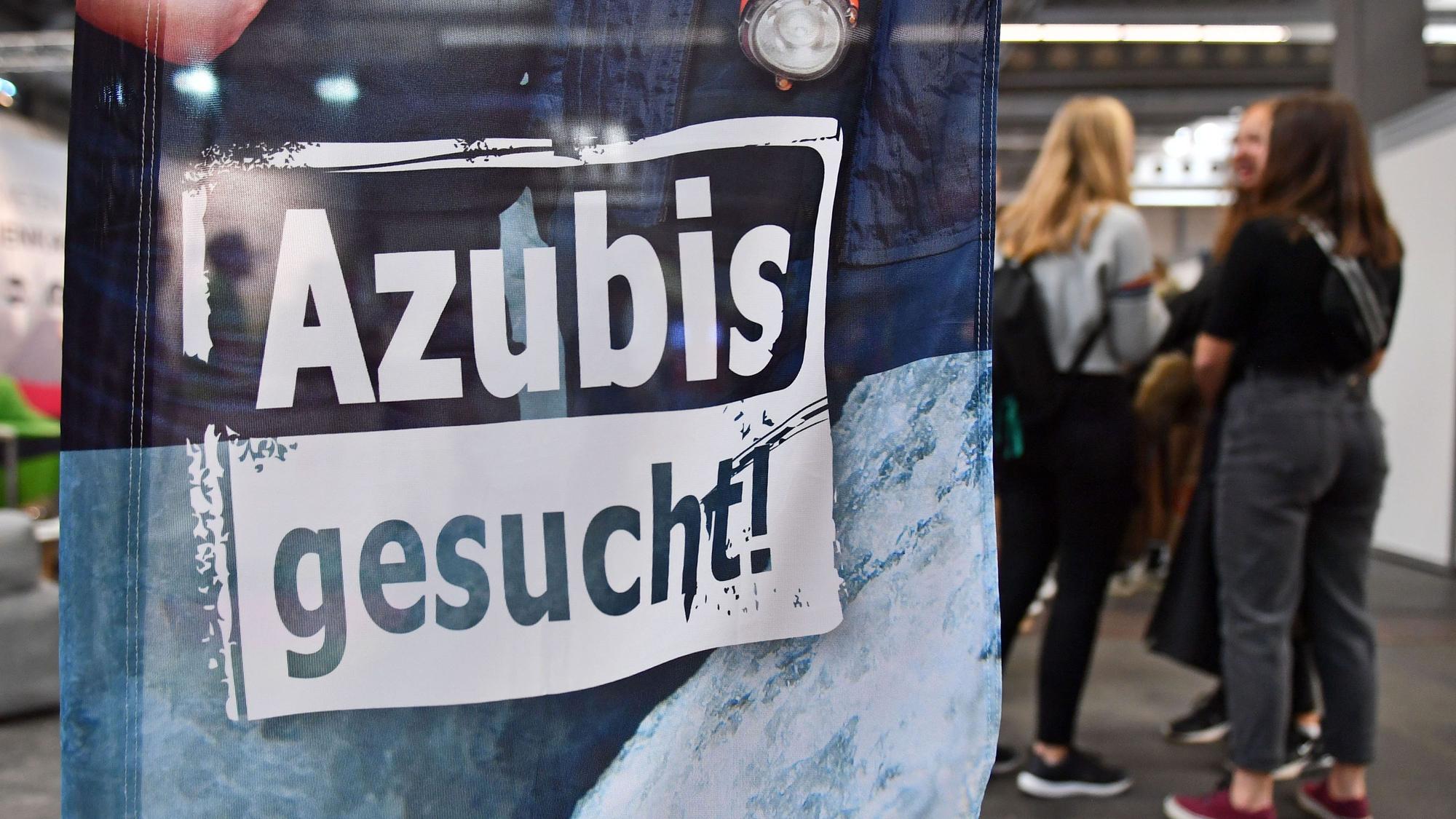„Azubis gesucht“ steht auf einem Banner bei einer Berufsorientierungsmesse.