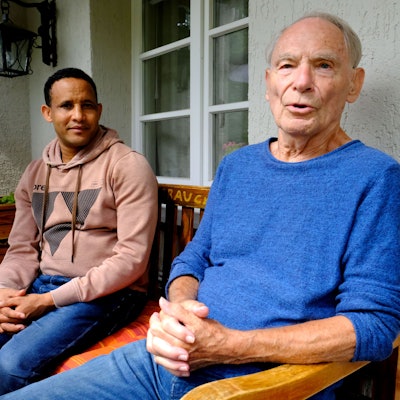 Dr. Herbert Kaefer, 86, sitzt mit seinem Adoptivsohn Tesfay auf dem Balkon seines Hauses am Gemünder Marienplatz.