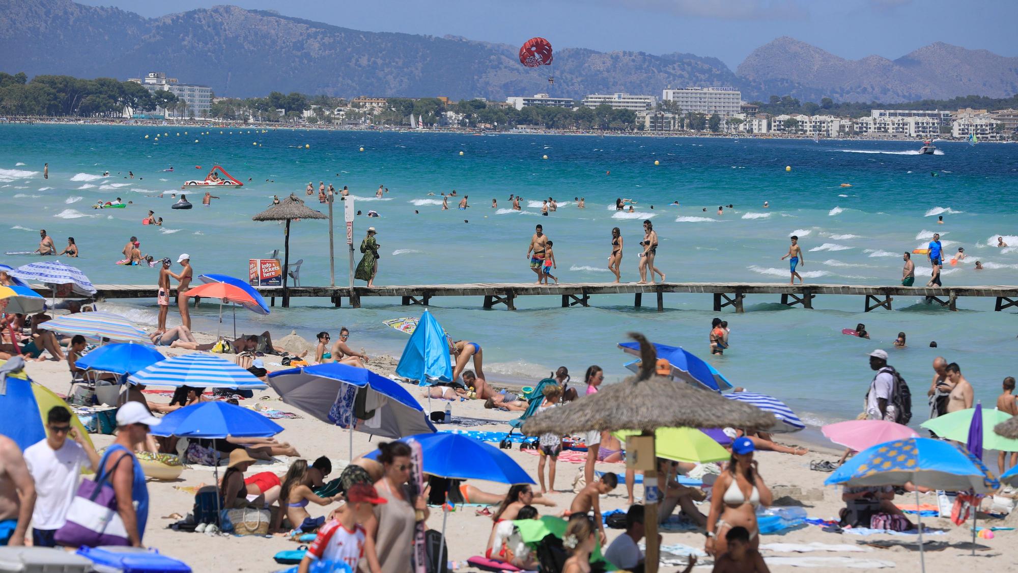 27.07.2024, Spanien, Muro: Menschen sonnen sich am Playa de Muro. Mallorca erwartet die erste Hitzewelle des Sommers. Foto: Clara Margais/dpa +++ dpa-Bildfunk +++