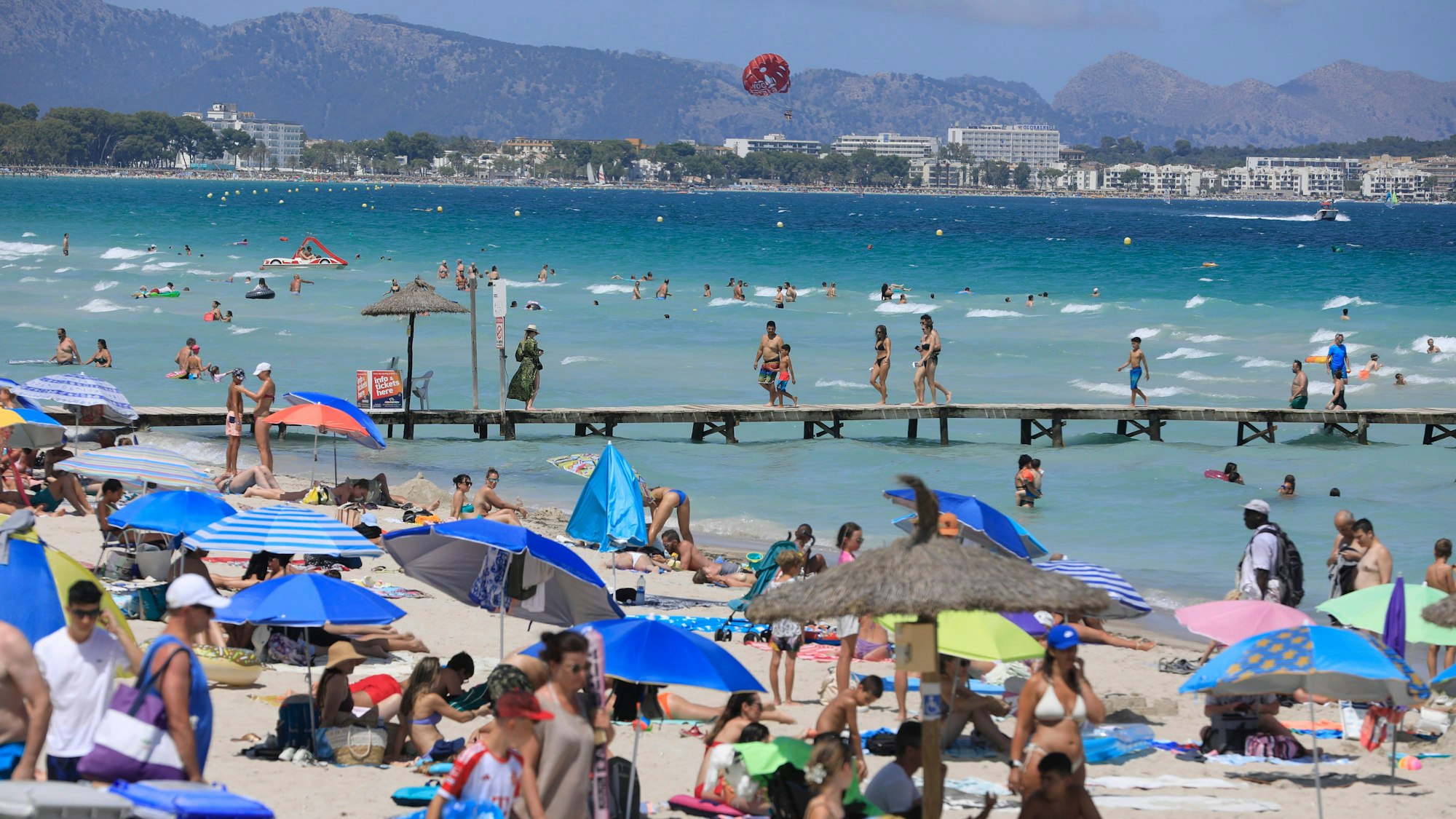 27.07.2024, Spanien, Muro: Menschen sonnen sich am Playa de Muro. Mallorca erwartet die erste Hitzewelle des Sommers. Foto: Clara Margais/dpa +++ dpa-Bildfunk +++