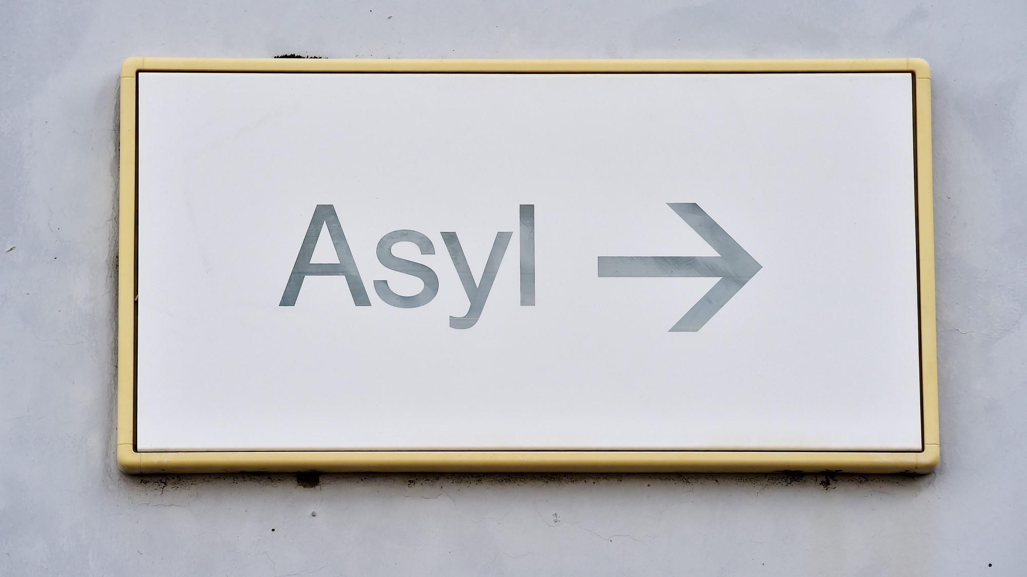 Ein Schild mit der Aufschrift ´Asyl» hängt in einer Landeserstaufnahme für Asylbewerber an einer Wand