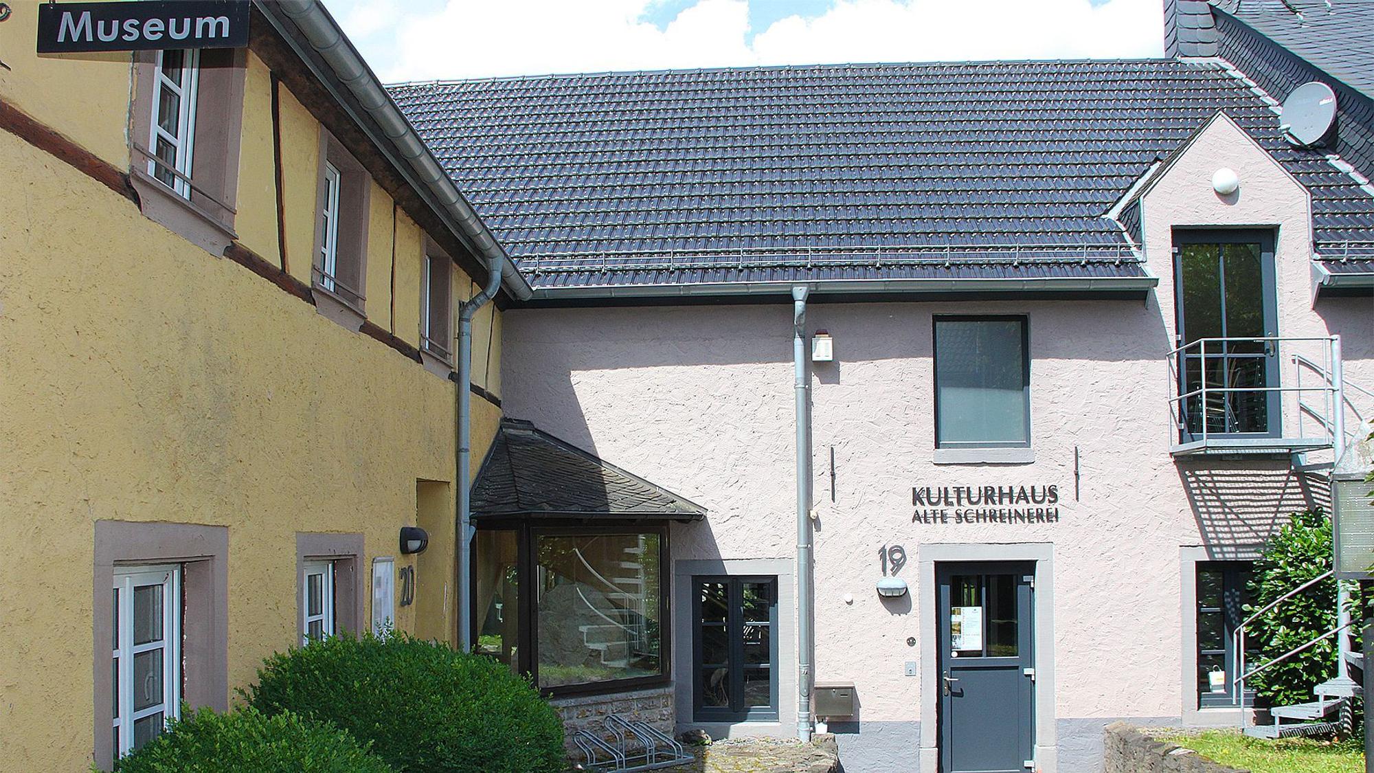 Frontal ist das Kulturhaus in der alten Schreinerei in Hillesheim zu sehen, links das gelb angestrichene Haus, dessen künftige Nutzung noch unklar ist.