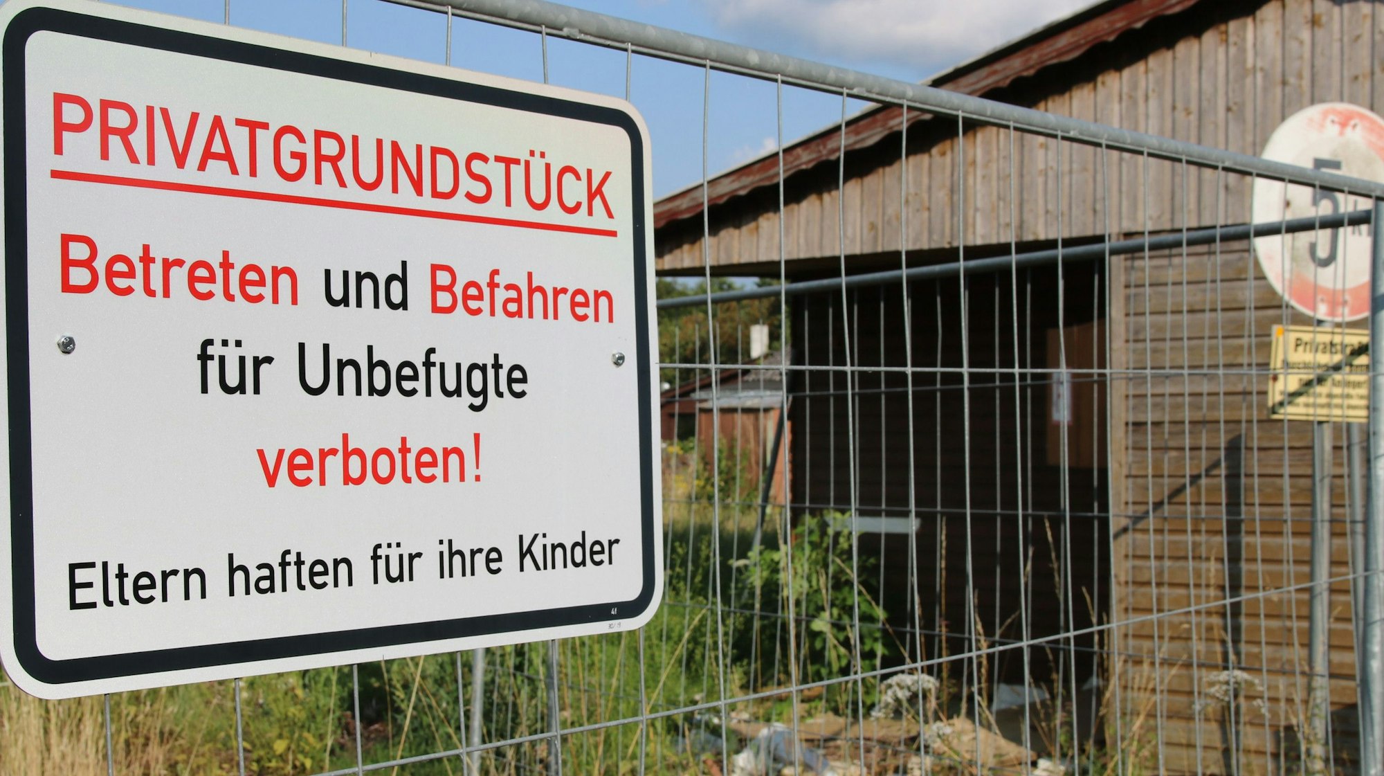 Betrete und Befahren verboten, steht auf einem Schild, das an einem Bauzaun befestigt ist.