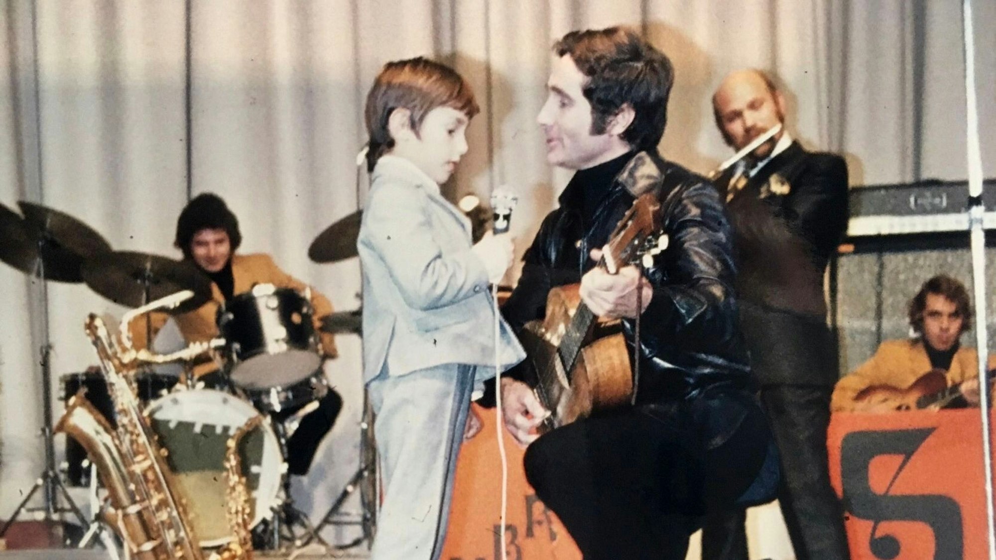Hermann-Josed Gemünd als Siebenjähriger mit Freddy Quinn. Der Sänger hält eine Gitarre in der Hand und kniet neben dem Jungen.