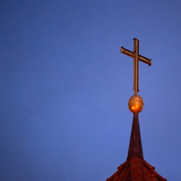 Ein Kreuz steht auf der Kirchturmspitze