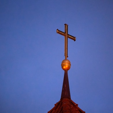 Ein Kreuz steht auf der Kirchturmspitze