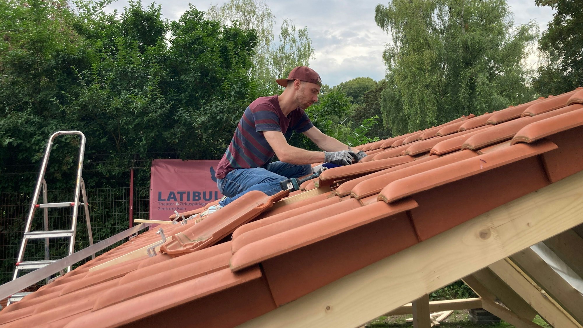 Vincent Sparrenberg (27) montiert eine Halterung auf dem Übungsdach.