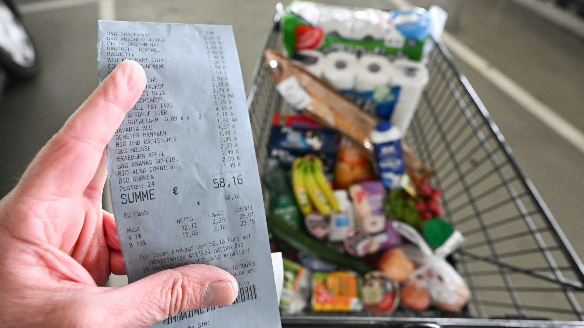 Ein Verbraucher hält nach einem Einkauf in einem Supermarkt einen Kassenzettel in der Hand.