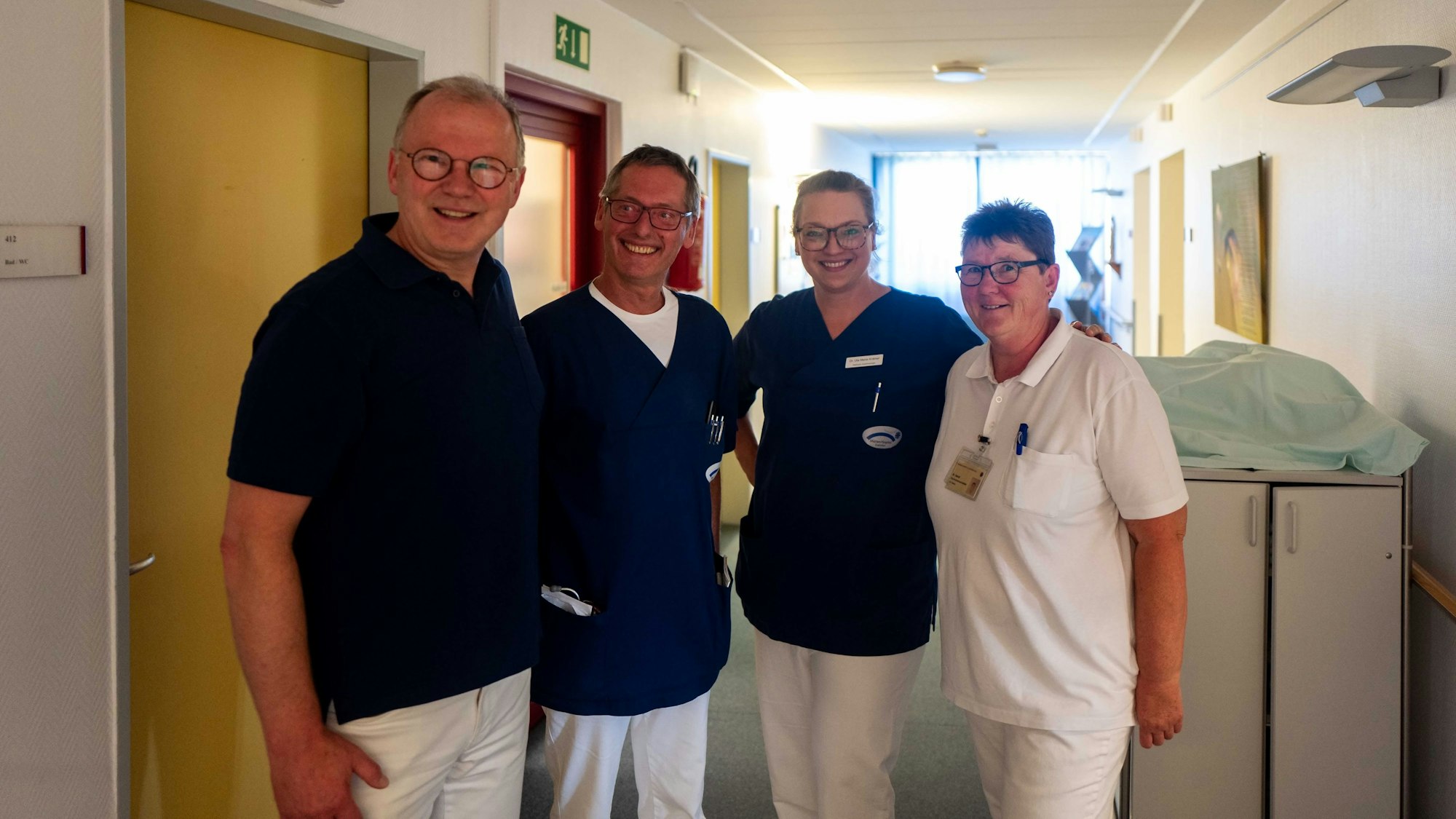 Prof. Dr. Michael Loick, Oberarzt Dr. Arvid Bonn, Dr. Uta Maria Krämer und Schwester Uschi stehen auf dem Krankenhausflur.