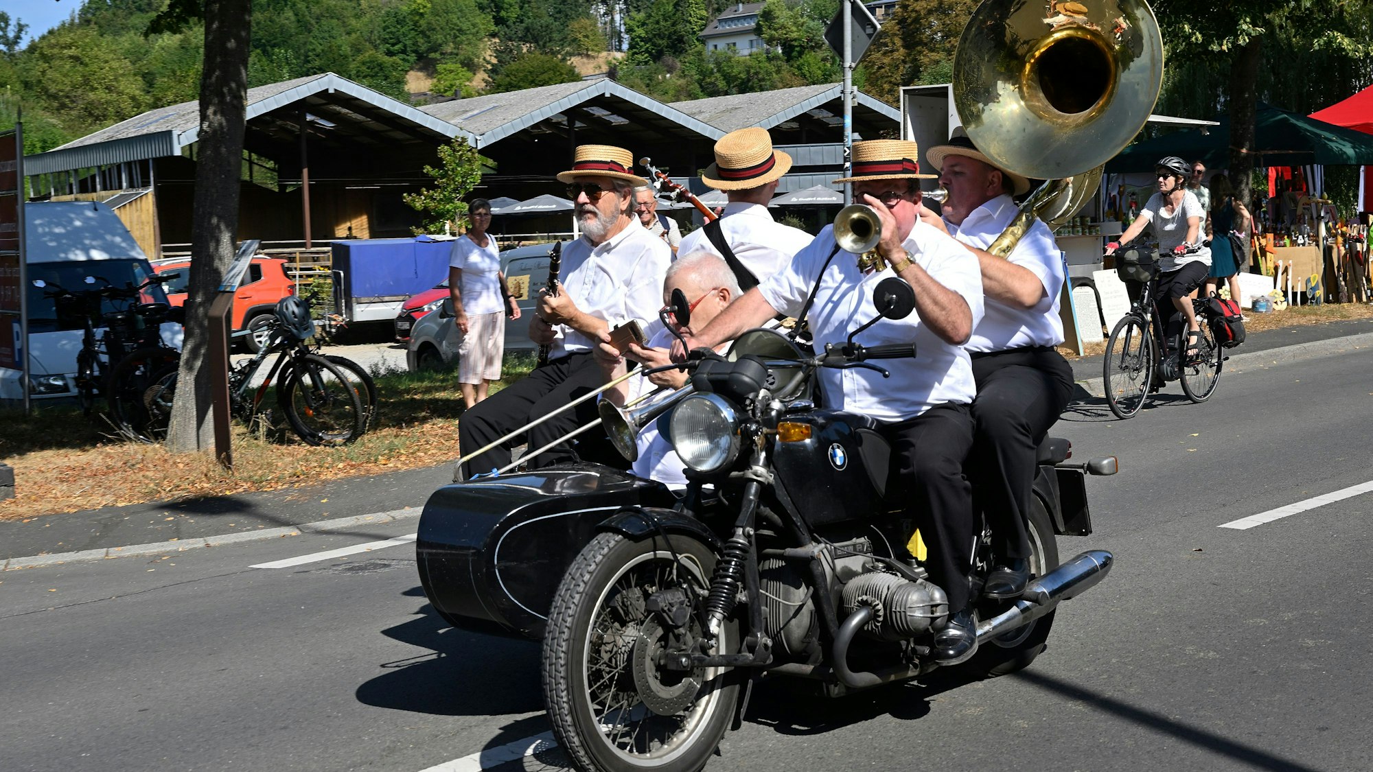 Dixielandmusiker fahren auf einem Motorrad mit Beiwagen.