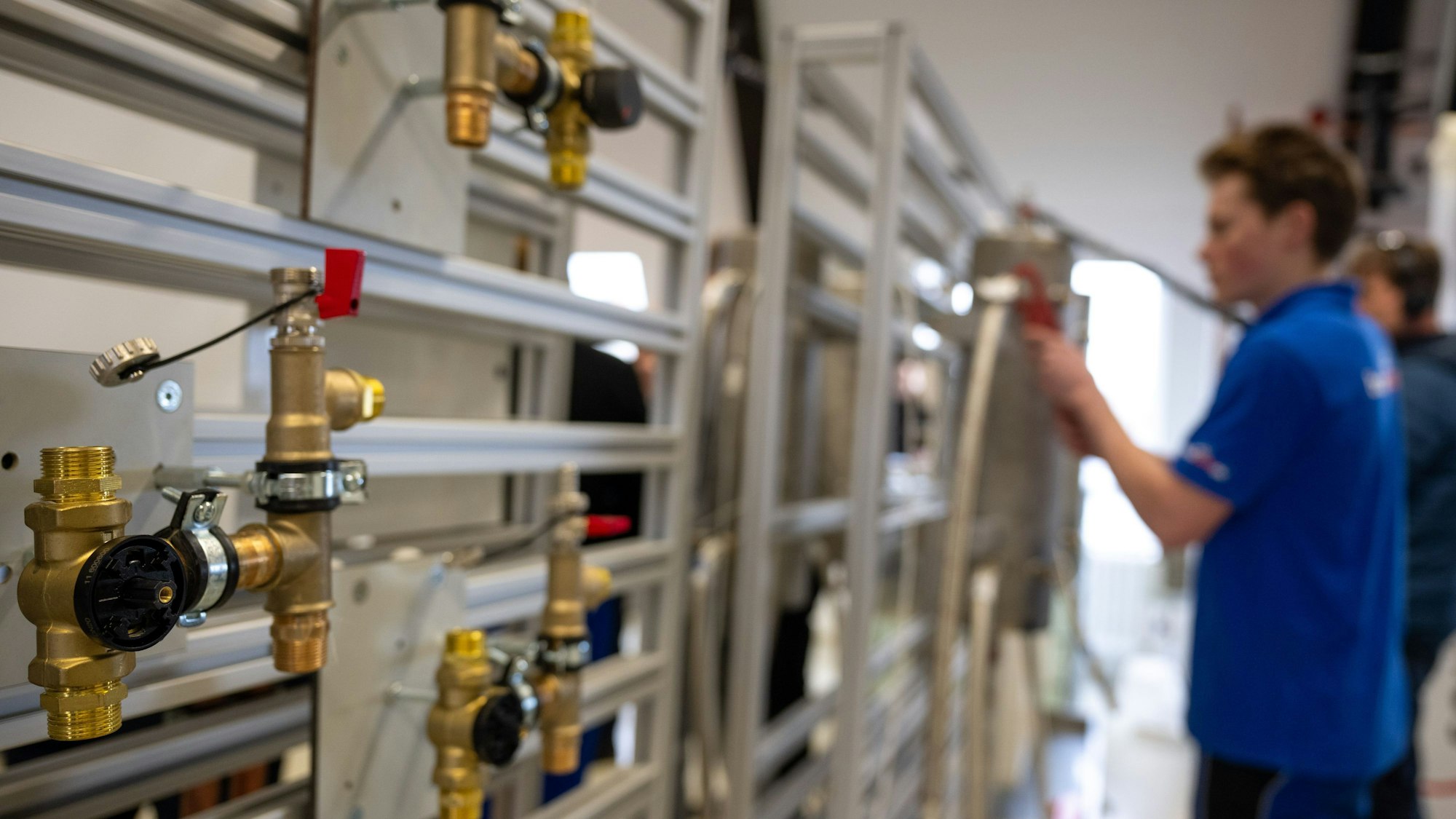 Ein Azubi arbeitet an einer Anlage der Innung Sanitär, Heizung und Klima.