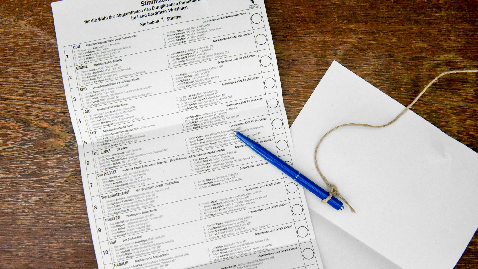 Ein Stimmzettel zur Europawahl liegt auf einem Tisch, daneben ein blauer Stift.