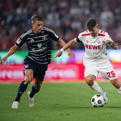 Hamburgs Miro Muheim (l) und Jean-Luc Dompe (r) kämpfen mit Kölns Jan Thielmann um den Ball.
