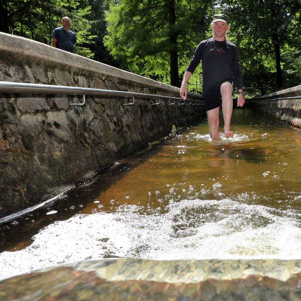 Ein Mann geht durch das Tretbecken der Wassertretstelle im Königsforst.