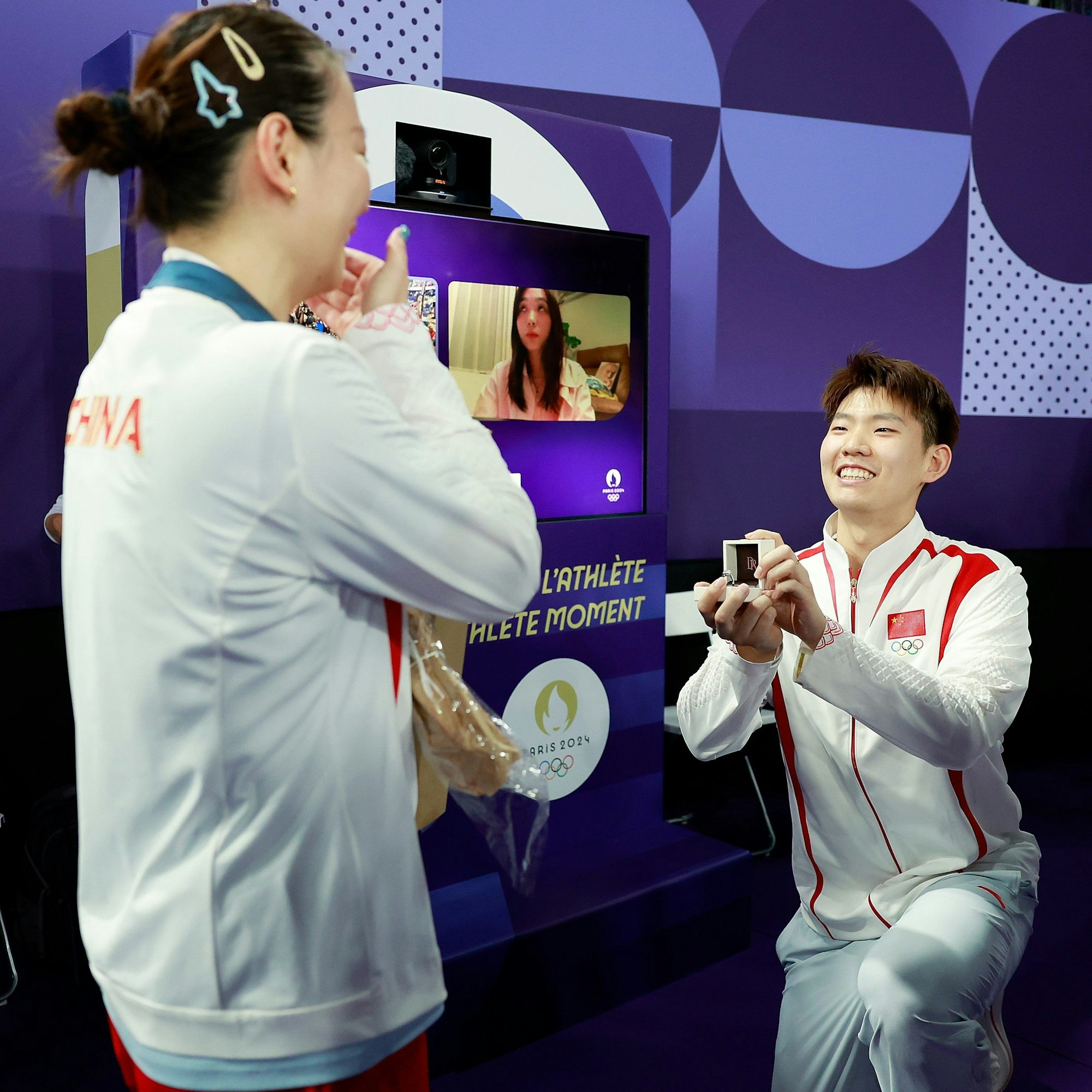 Der chinesische Badmintonspieler Liu Yuchen (r) macht der Goldmedaillengewinnerin Huang Ya Qiong nach dem Goldmedaillenspiel im gemischten Doppel (Zheng Siwei/Huang Yaqiong) einen Heiratsantrag.