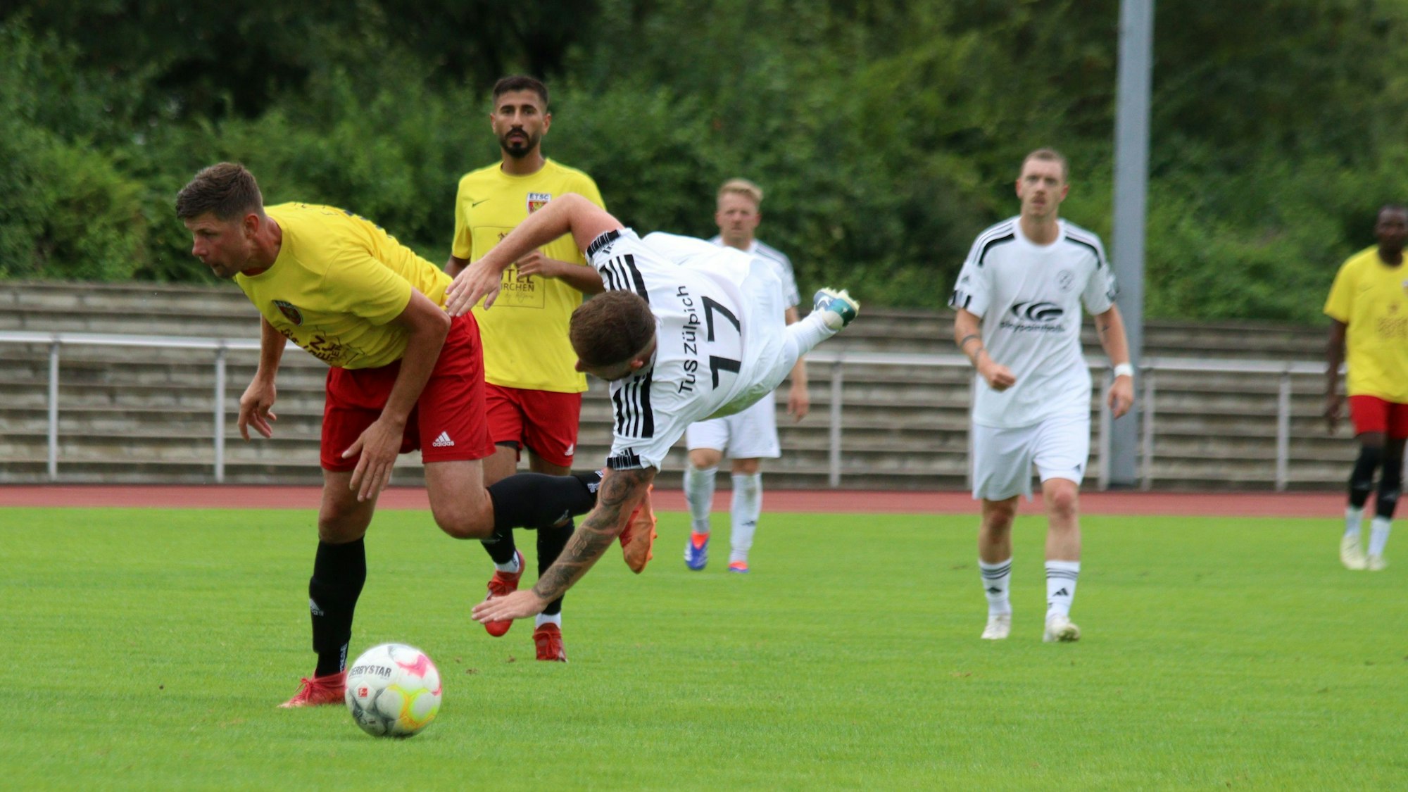 Ein Fußballspieler steht quer in der Luft, nachdem er mit einem Gegenspieler zusammengeprallt ist.