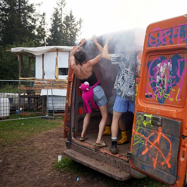 In einem bunt bemalten Transporter tanzen mehrere Festivalbesucher.