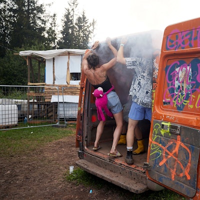 In einem bunt bemalten Transporter tanzen mehrere Festivalbesucher.