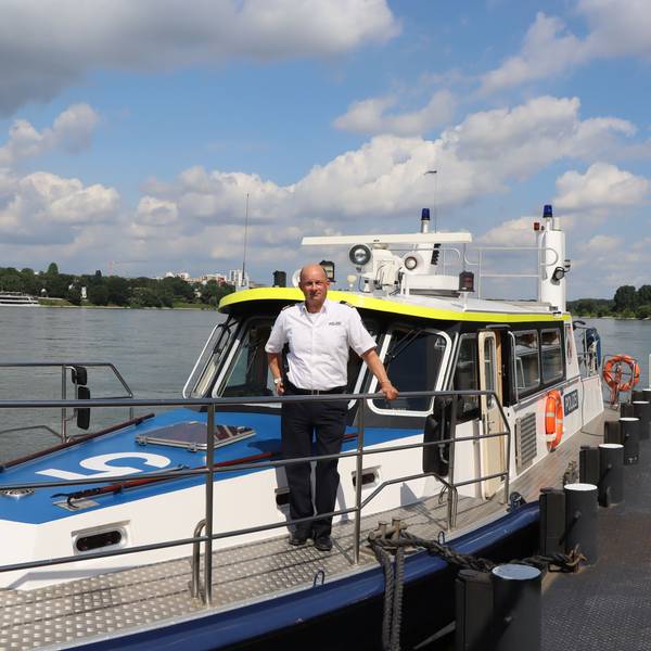 Ein Wasserschutzpolizist steht auf einem Boot.