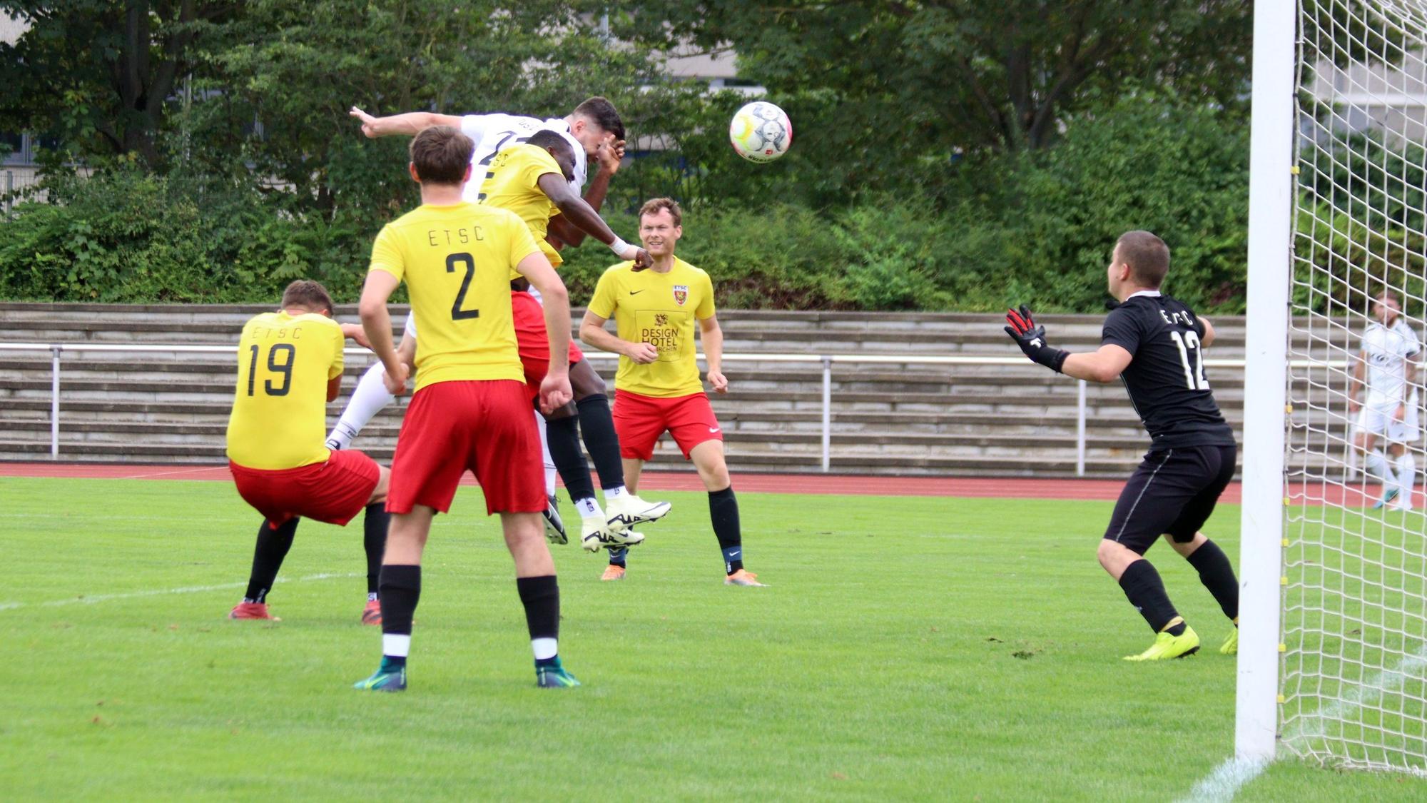 Ein Zülpicher Spieler springt nach einem Eckball hoch. Er ist umringt von Euskirchener Gegenspielern. Einer trifft ihn mit der Hand im Gesicht.