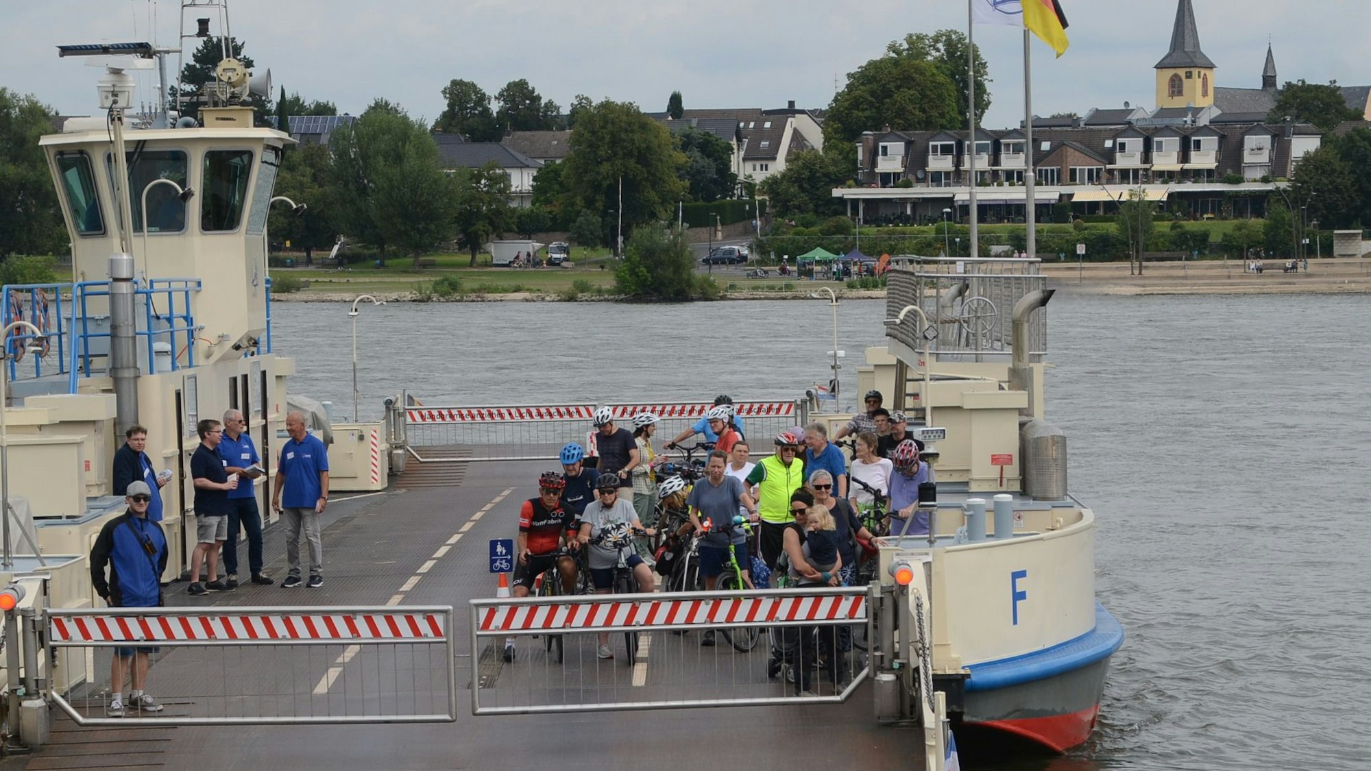Eine Rheinfähre legt an. An Bord sind nur Radfahrer.