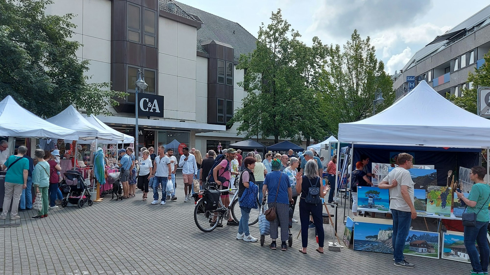 Verkaufsstände und Besucher des Kunsthandwerkermarkts auf dem Klosterplatz in Euskirchen.