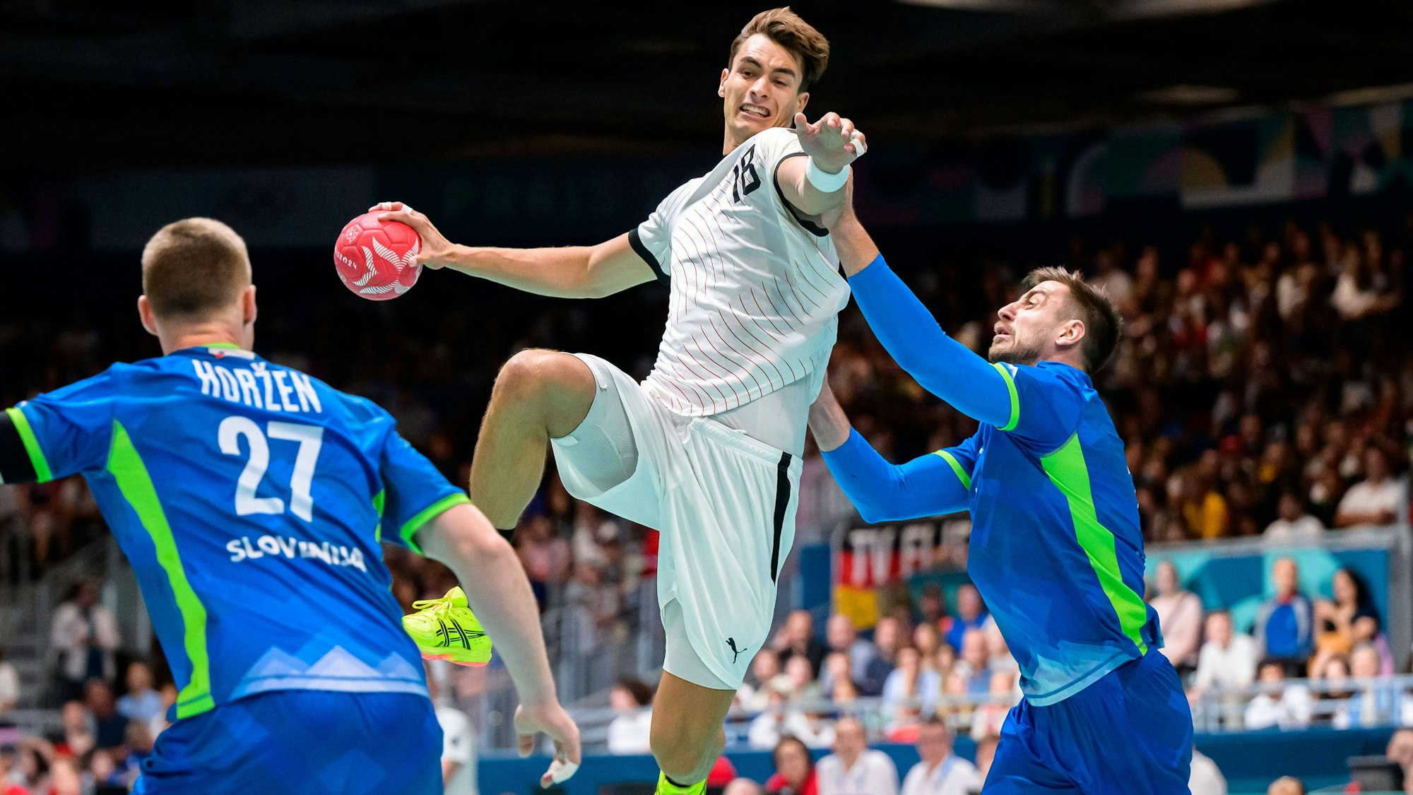 Julian Köster versucht mit einem Sprungwurf die slowenische Abwehr zu überwinden. Dabei steht ihm unter anderem sein VfL-Mannschaftskollege gegenüber.