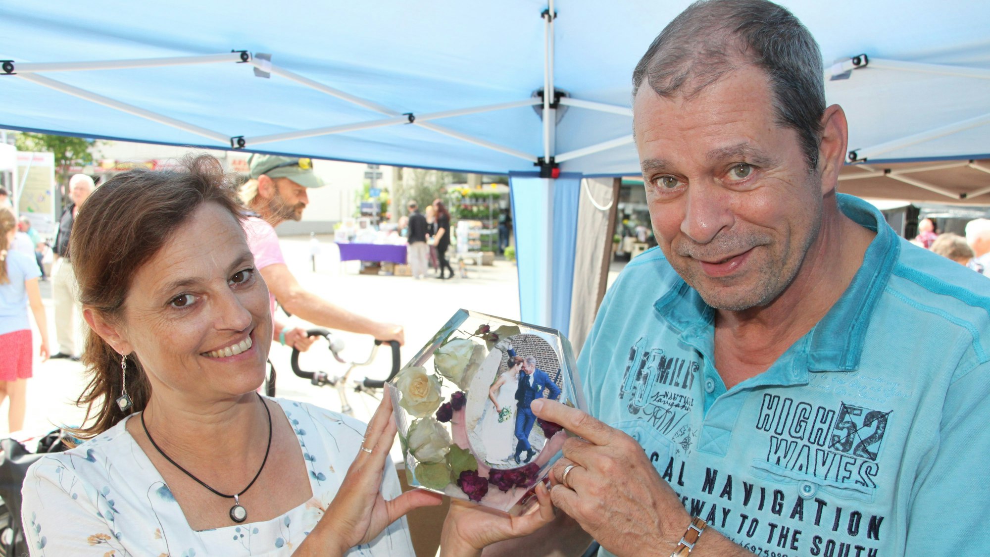 Jochen Teschke und Melanie Zehnpfennig zeigen ein in Epoxidharz an gegossenes Foto.