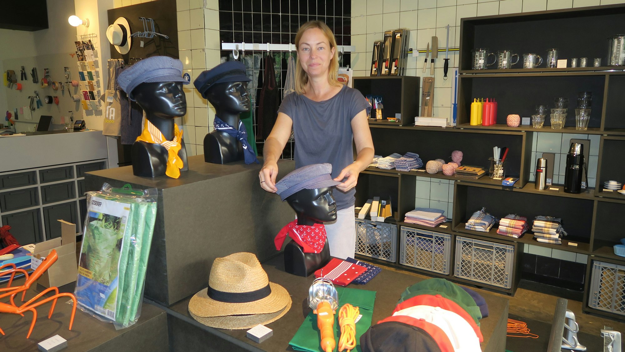 Anna Lederer mit Elbsegler-Kappen und Panama-Hüten, die nach ihrer Auskunft auch von australischen Rangern getragen werden. Dazu Erlenmeyerkolben, Waagen, Eierbecher, Sandalen etc aus ihrem Sortiment.