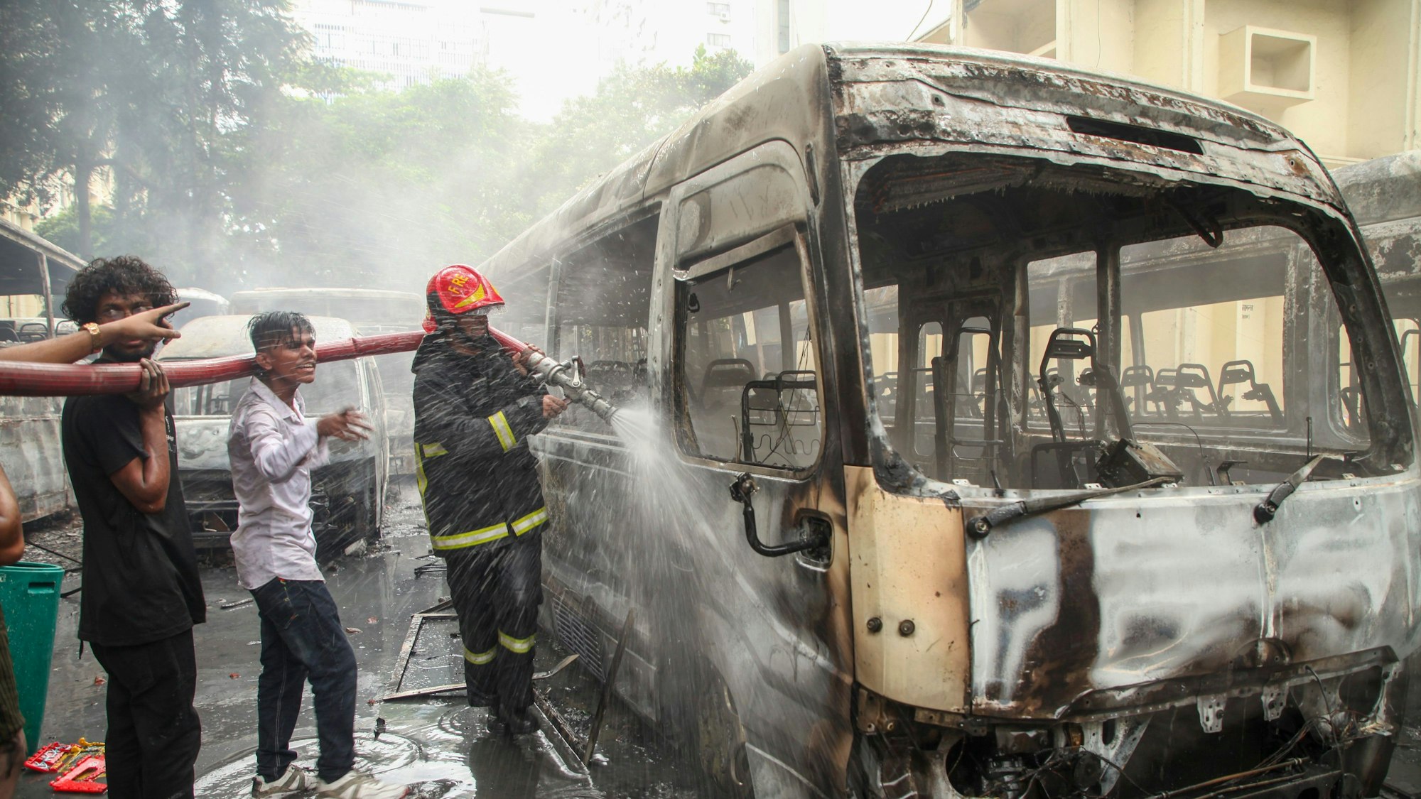 Feuerwehrleute löschen Feuer in einem der Busse der Bangabandhu Sheikh Mujib Medical University, die Berichten zufolge von Randalierern in Dhaka in Brand gesetzt worden sein sollen. Die Demonstranten fordern Gerechtigkeit für die Opfer, die bei den jüngsten landesweiten Zusammenstößen getötet wurden, sowie den Rücktritt der Premierministerin.