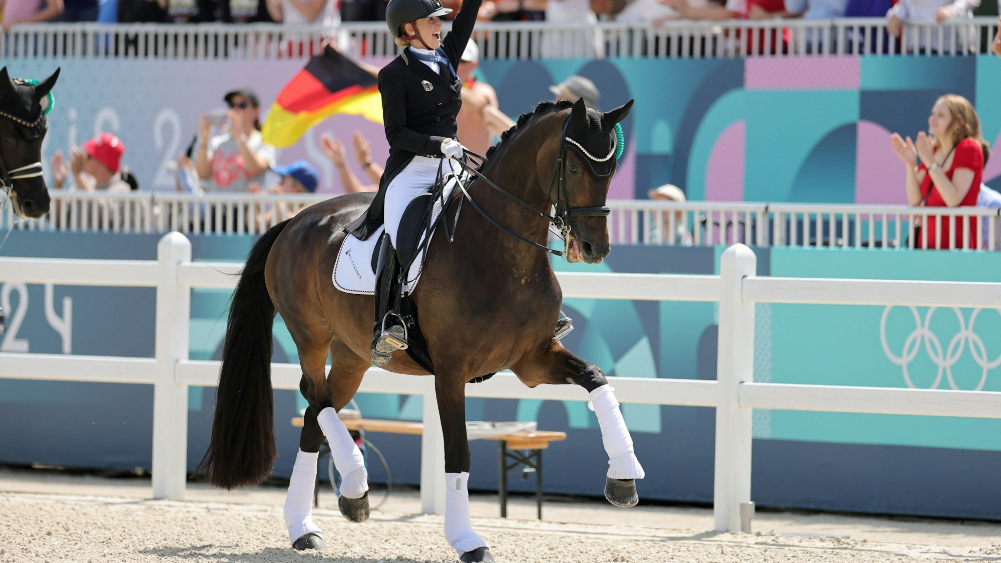 04.08.2024, Frankreich, Versailles: Olympia, Paris 2024, Pferdesport, Dressur, Einzel, Finale, Deutschlands Jessica von Bredow-Werndl jubelt nach der Siegerehrung über Gold.