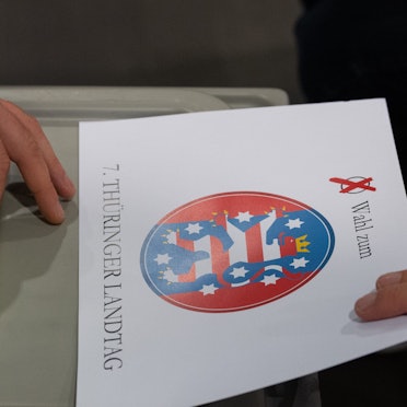 Ein Wähler wirft bei der Stimmabgabe zur Landtagswahl in Thüringen seinen Wahlzettel in einem Wahllokal in eine Wahlurne.