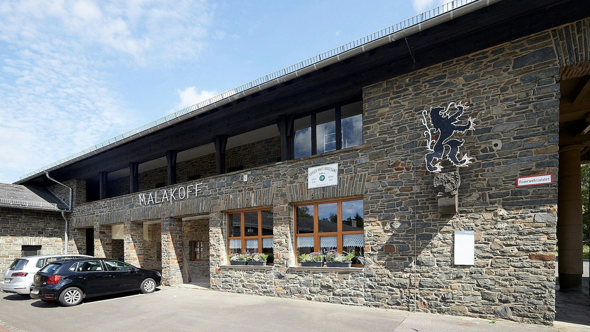 Der Schriftzug Malakoff prangt an einem alten Gebäude in Vogelsang, zwei Autos parken vor dem Haus. Einst war darin das Kasernengefängnis, nun ist dort ein Selbstversorgerhaus des Alpenvereins eingerichtet.