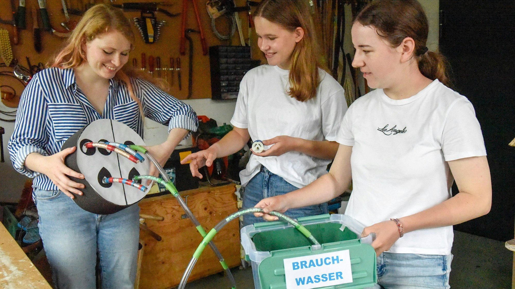 Drei junge Frauen mit ihrer Erfindung.
