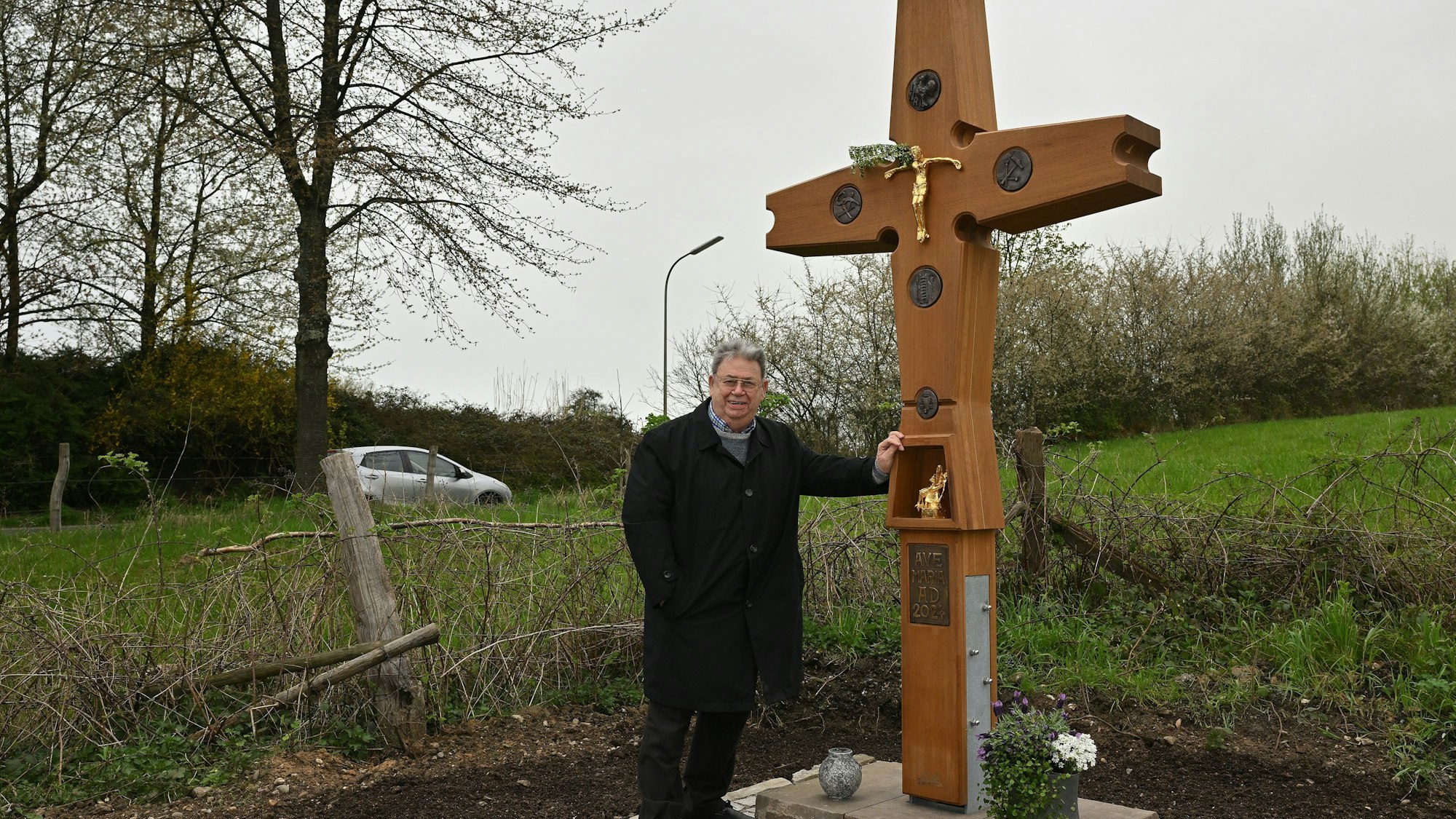 Walter Jansen steht neben einem neuen Wegegkreuz in Odenthal-Erberich.