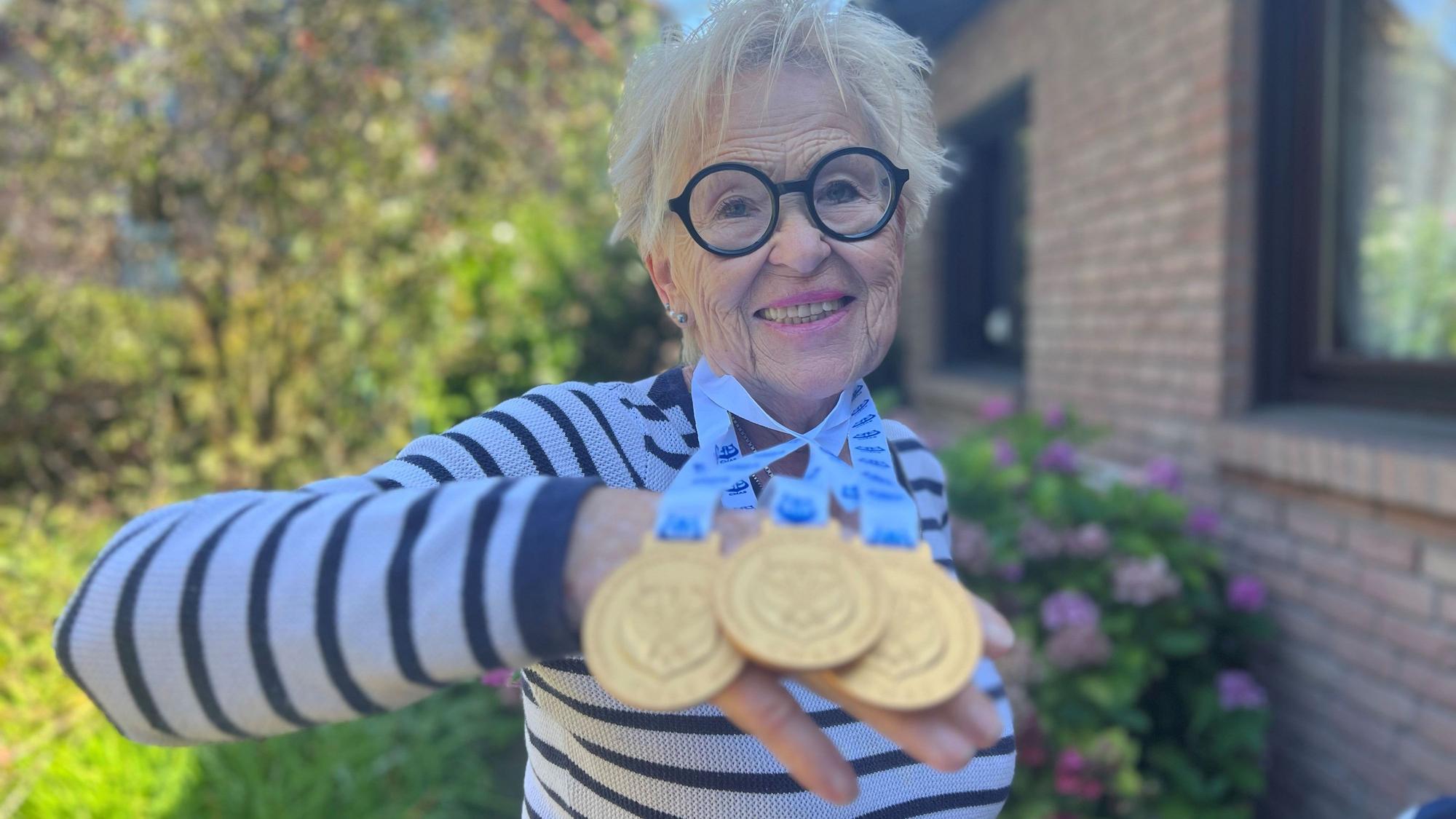 Hannelore Becker hält drei Gold-Medaillien in der Hand.