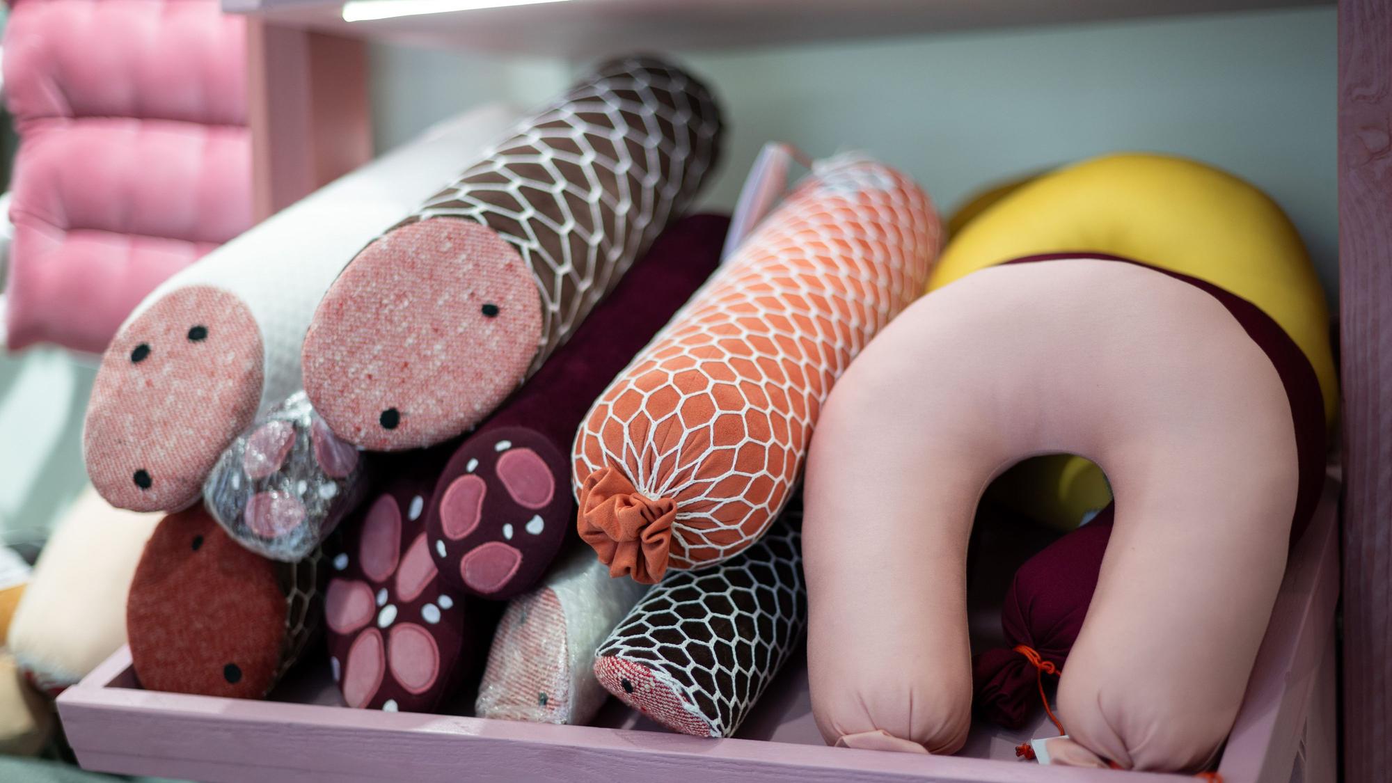 Kissen in Form von Würsten liegen im Ladengeschäft Aspik.store der Designerin Silvia Wald.