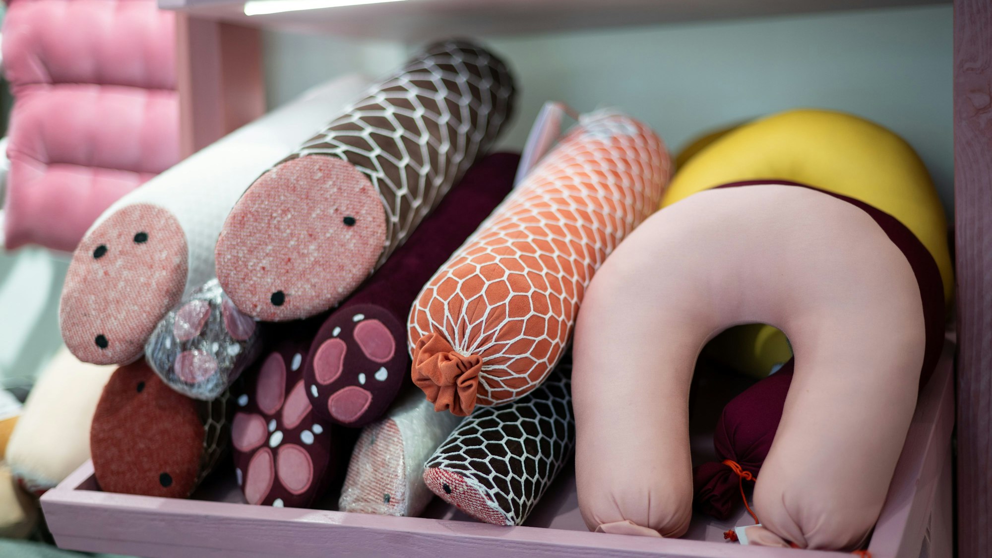 Kissen in Form von Würsten liegen im Ladengeschäft Aspik.store der Designerin Silvia Wald.