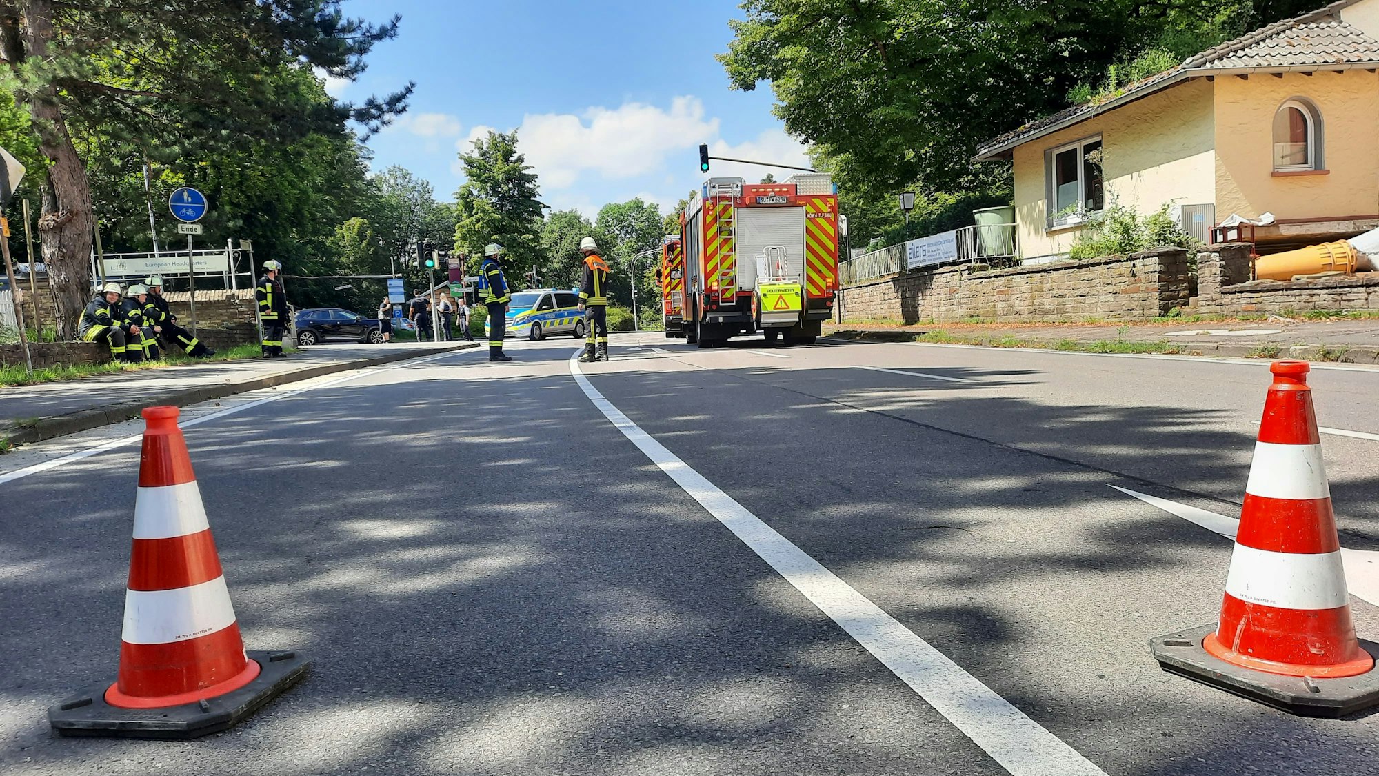 Pylone auf einer gesperrten Straße, im Hintergrund ein Feuerwehrfahrzeug.