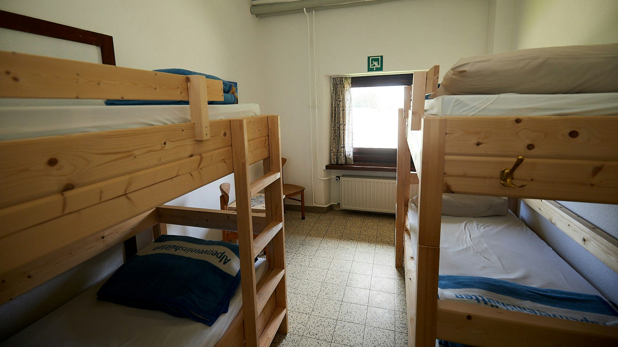 Zwei Stockbetten aus hellem Holz bieten in einem Vierbettzimmer der Alpenvereinshütte in Vogelsang Schlafmöglichkeiten.