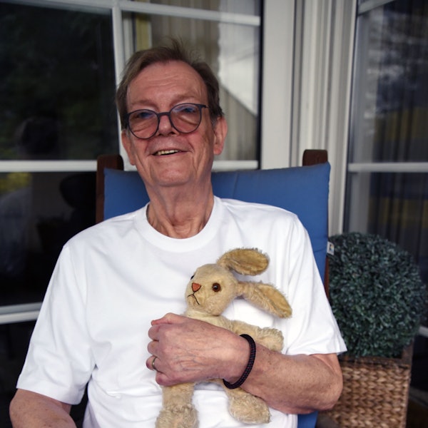 Zu sehen ist ein Mann, der einen Plüschhasen im Arm hält.