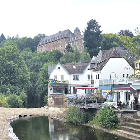 Blick auf die Furt, die aus Kies besteht. Im Hintergrund ist das Schleidener Schloss zu sehen.