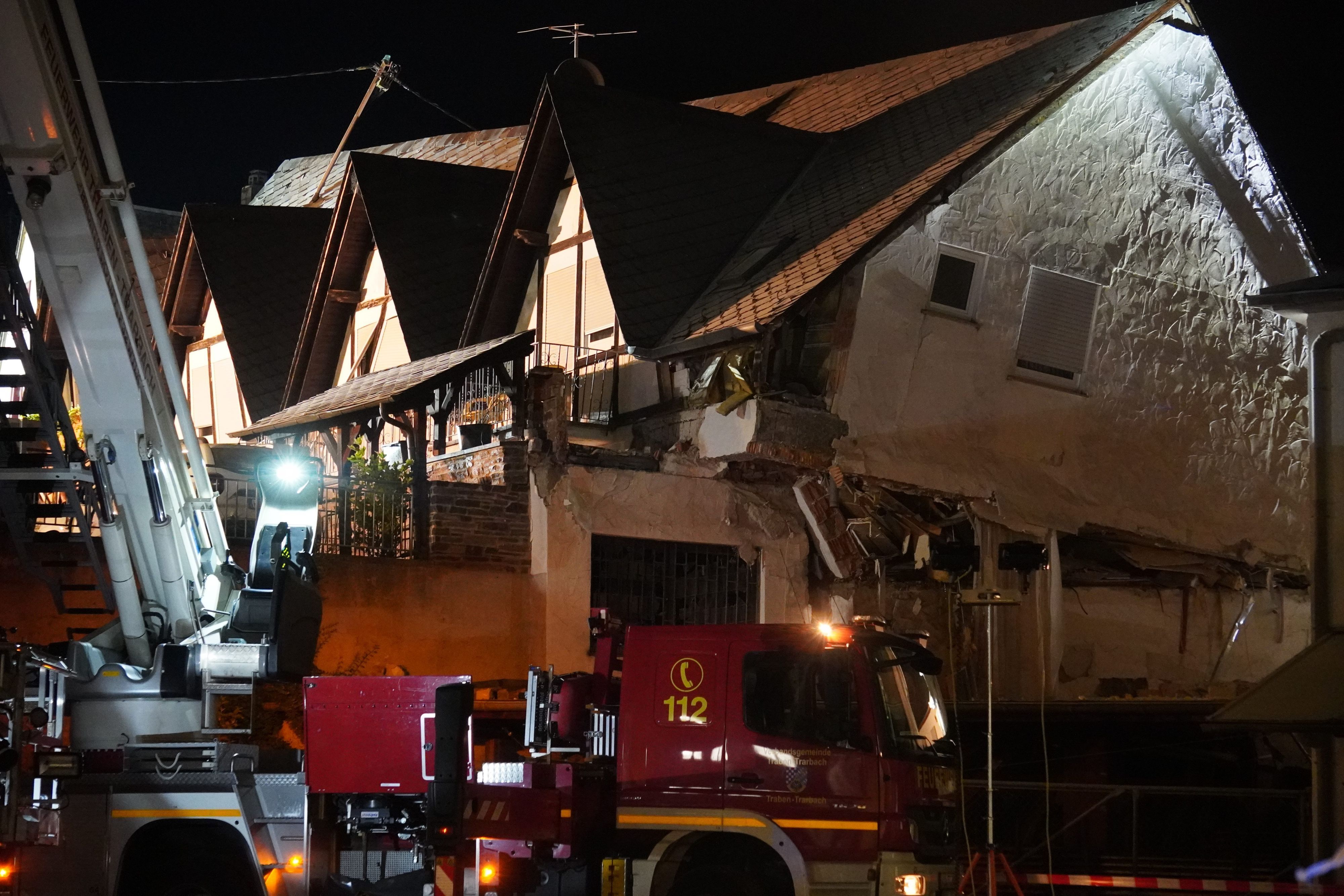 Ein Fahrzeug der Feuerwehr steht vor einem eingestürzten Hotel.