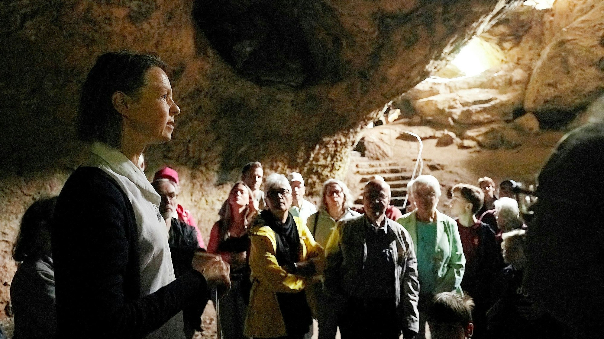 Dr. Anne Katharina Zschocke und eine Gruppe Menschen stehen in der Kakushöhle bei Mechernich.