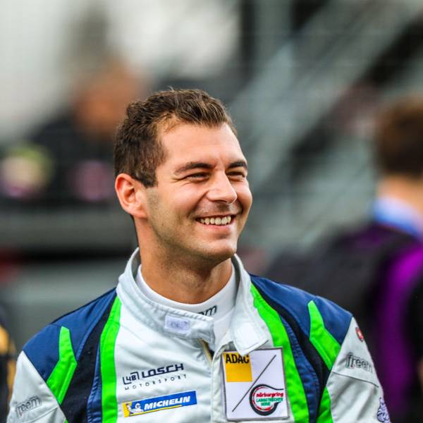 Rennfahrer Tobias Müller trägt seinen Rennoverall und lacht.