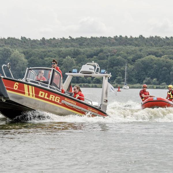 Mitglieder der Deutschen Lebens-Rettungs-Gesellschaft fahren über einen Fluss.