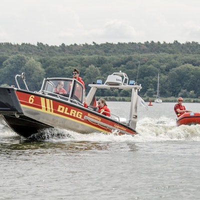 Mitglieder der Deutschen Lebens-Rettungs-Gesellschaft fahren über einen Fluss.